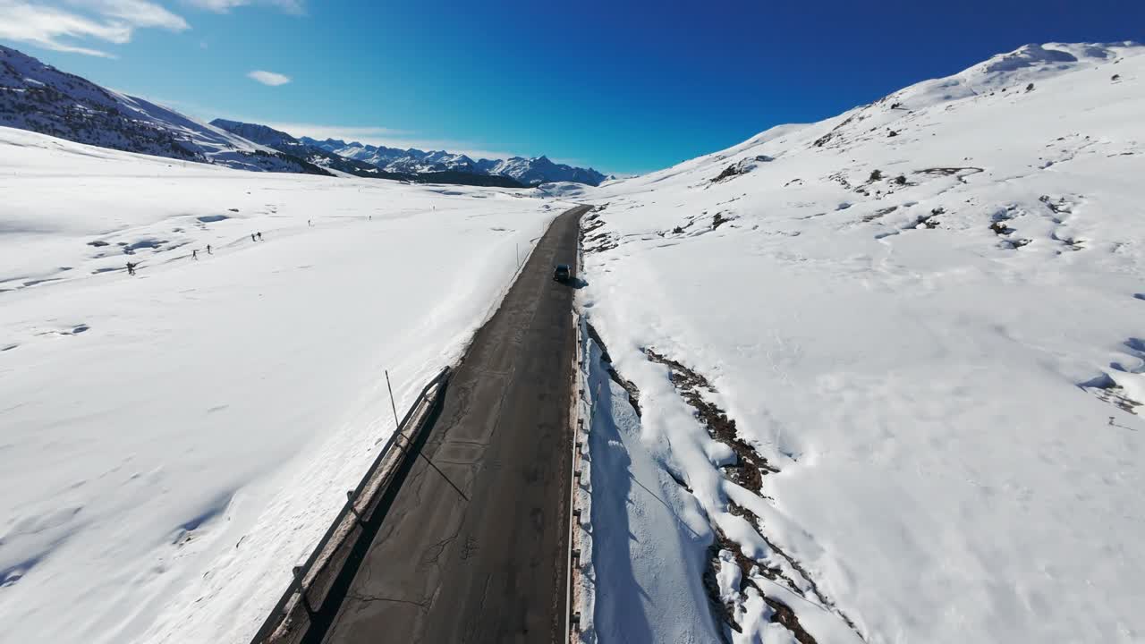 A car driving on a road in a snowy environment in the middle of nature