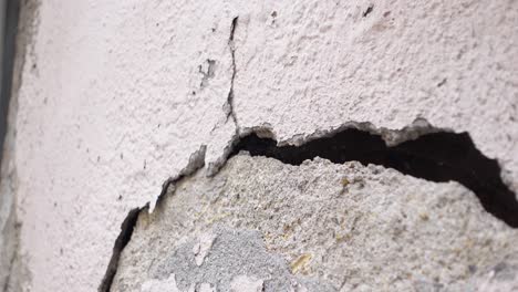 damaged exterior wall with cracks and peeling paint