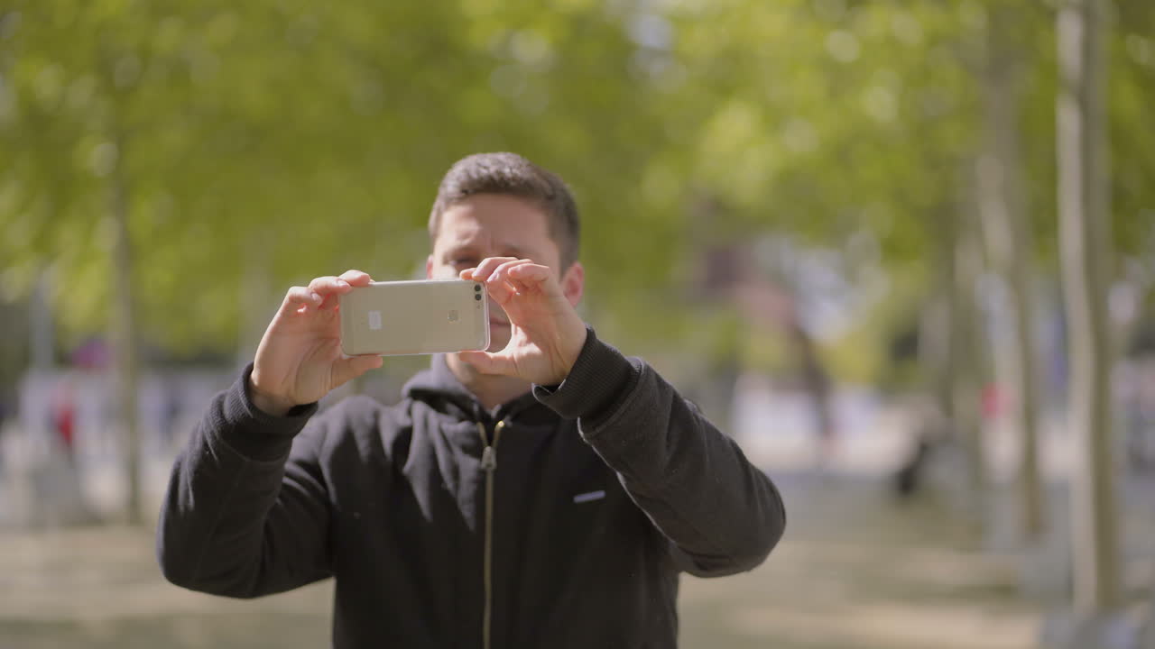 스마트폰으로 밖에서 사진을 찍는 남자