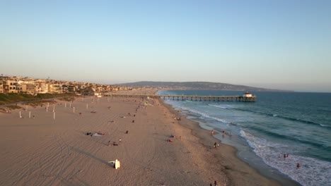 Fliegen-Sie-Am-Sandstrand-Mit-Vielen-Touristen-Am-Manhattan-Beach-Pier,-Kalifornien,-USA-Davon