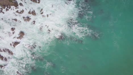 Overhead-aerial-tracking-of-the-rugged-New-Zealand-coastline-with-rocks-and-waves