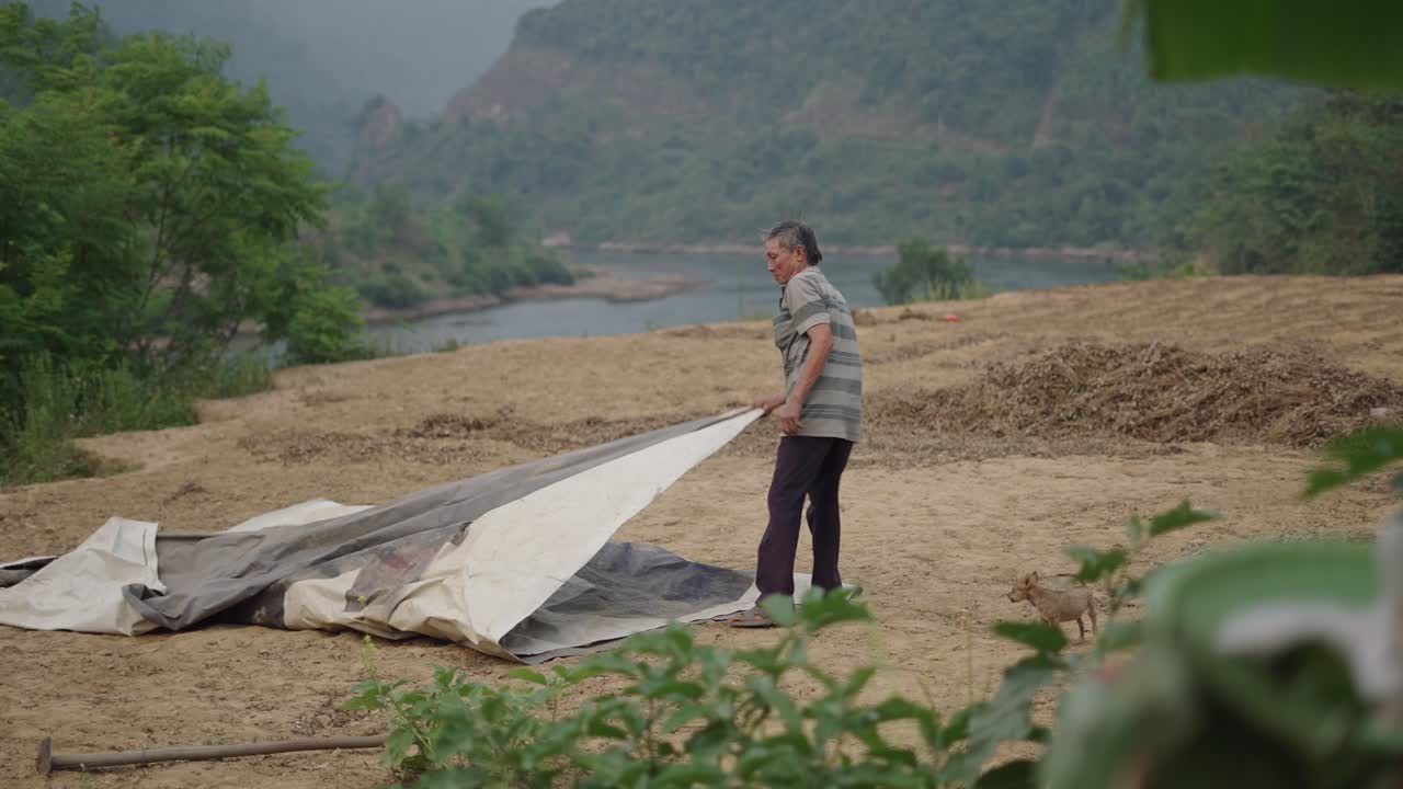 Elderly Farmer Working in a Rural Field by a River
