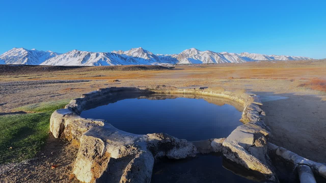 Winter early morning blue sky natural hot springs hot tub soak sunny sky snow covered Mammoth Mountain Minarets aerial drone Convict Canyon Hilltop Whitmore Wild Willys Hot Springs peaceful steam
