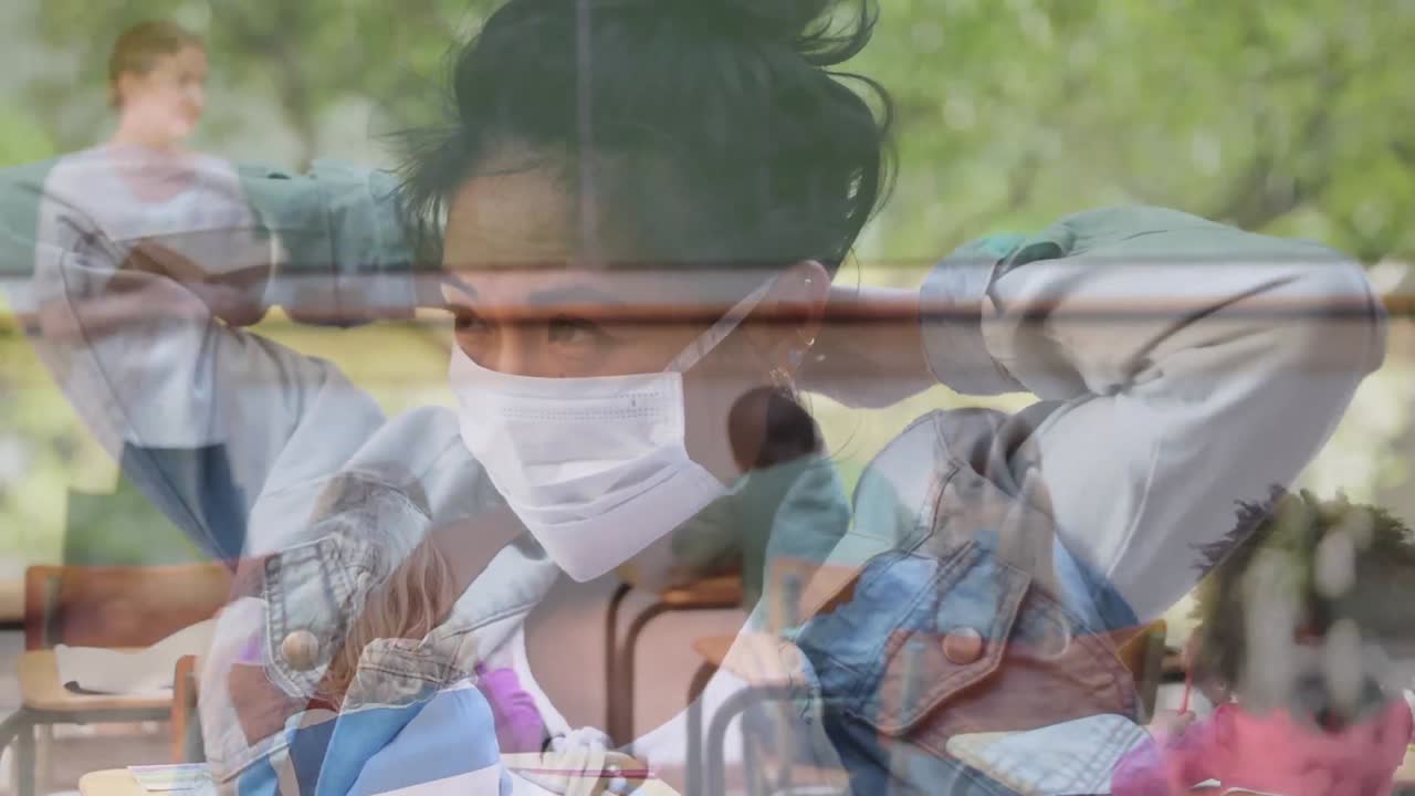 교실 에서 가르치는 여자 교사 에 대항 하여 얼굴 마스크 를 착용 한 여자