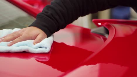 car cleaner polishing rear of shiny luxury sports car