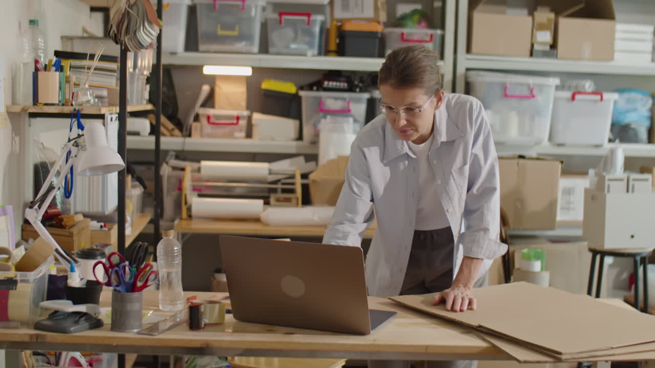 Mulher usando laptop no escritório do serviço de entrega