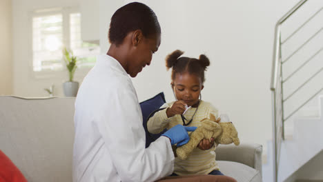 Niña-Afroamericana-Usando-Estetoscopio-Y-Sonriendo-Durante-La-Visita-Médica-A-Domicilio