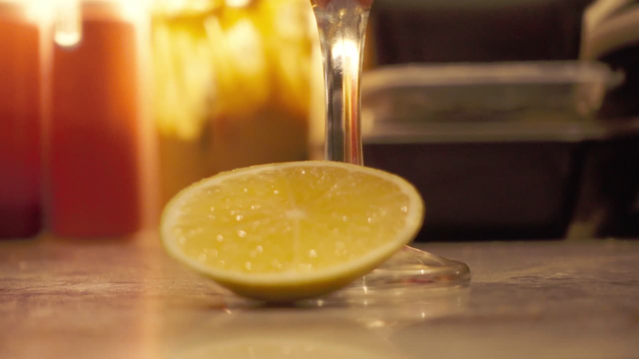 Primo piano di miele dorato che cola su una fetta di limone su una superficie della cucina