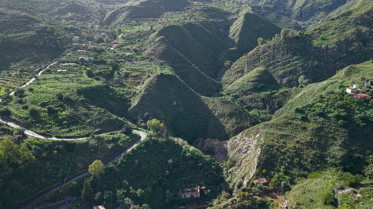 Lush green hills surround Taormina's elevated highway in Sicily's landscape