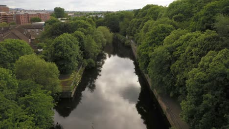 Eine-Sanfte-Drohnenaufnahme,-Die-Einen-Mit-Bäumen-Gesäumten-Stadtfluss-Hinunterfährt-|-Das-Wasser-Von-Leith,-Edinburgh,-Schottland-|-Aufnahme-In-4k-Mit-30-Fps