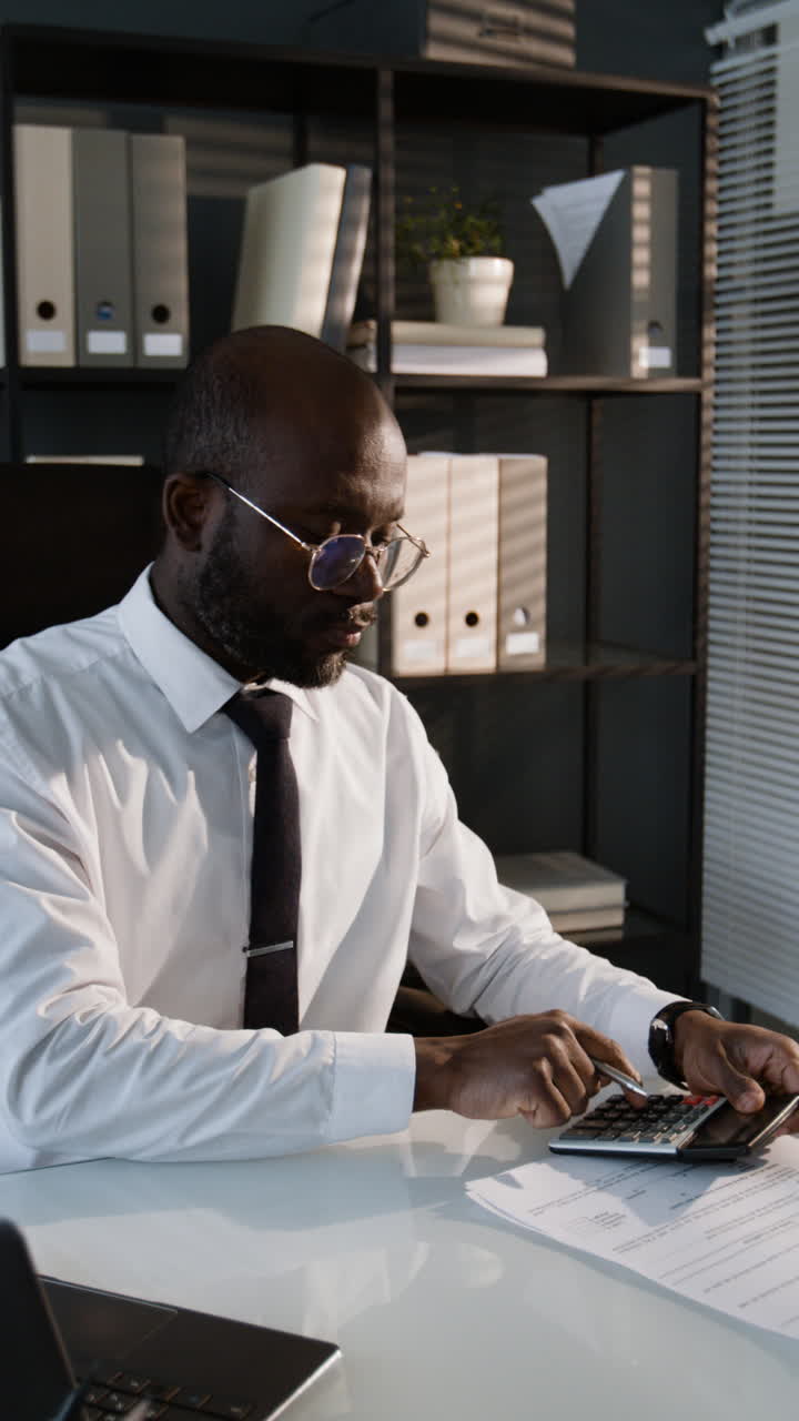 Businessman Working on Calculations in Office