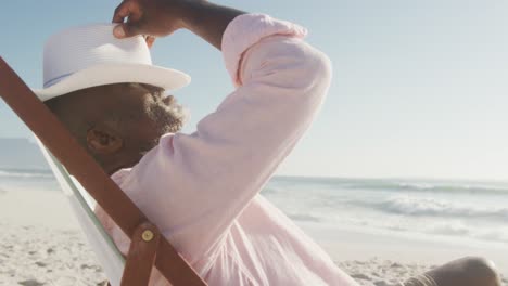 Älterer-Afroamerikanischer-Mann-Liegt-Auf-Sonnenliege-Am-Sonnigen-Strand