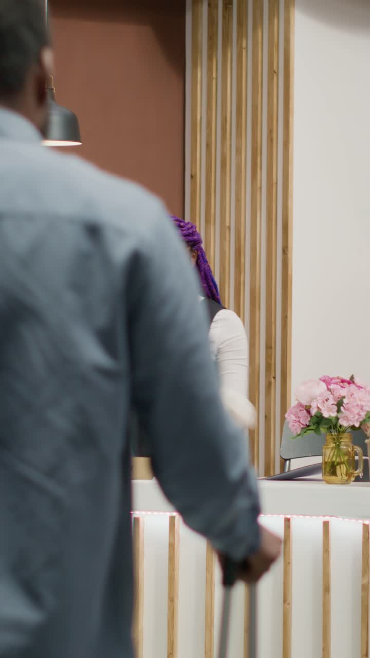 Video verticale Una persona effettua il check-in alla reception