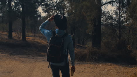 tipo caminando por el bosque con un libro en la mano