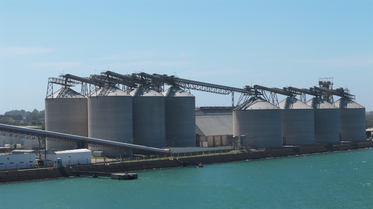estableciendo imágenes aéreas de los silos en el puerto de necochea, argentina. captura la infraestructura industrial, la actividad marítima y el paisaje costero circundante.