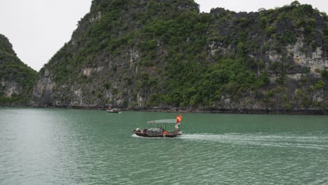 Barco-De-Crucero-En-La-Bahía-De-Ha-Long-Con-Acantilados-De-Piedra-Caliza-En-El-Fondo-En-Vietnam