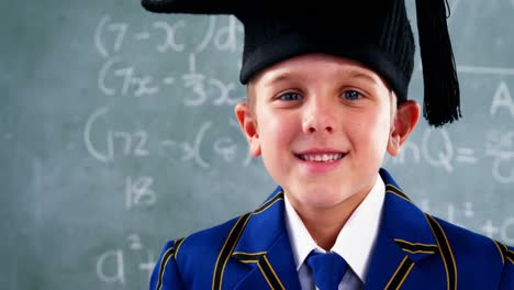 smiling schoolboy standing in classroom