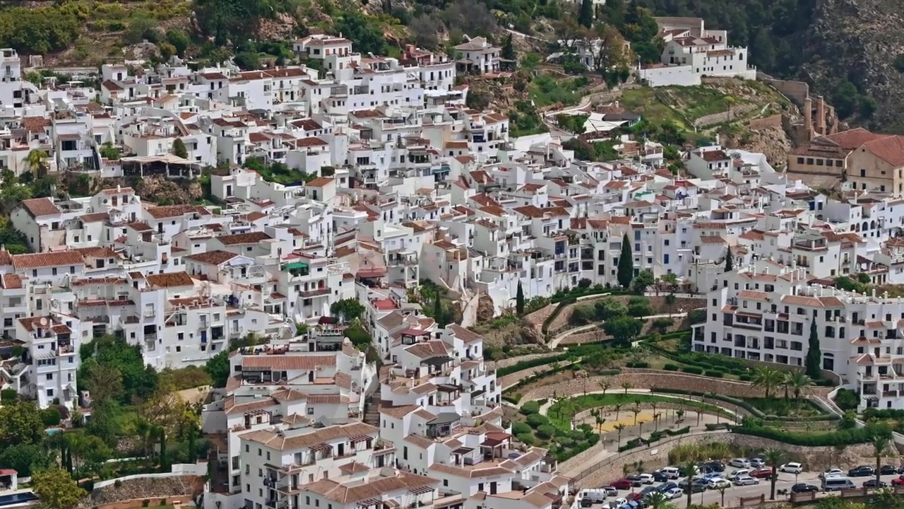 Droneoptagelser af Frigiliana, Andalusien, der viser lagdelte hvide huse på bjergskråninger, buede terrasser og bjerglandskab med filmisk telekompression
