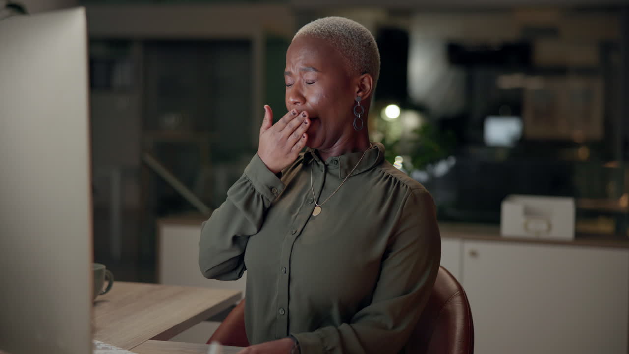 Tired woman yawning in the office