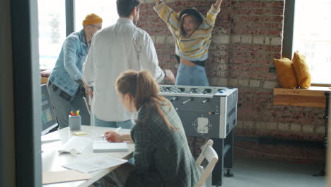 office team playing foosball