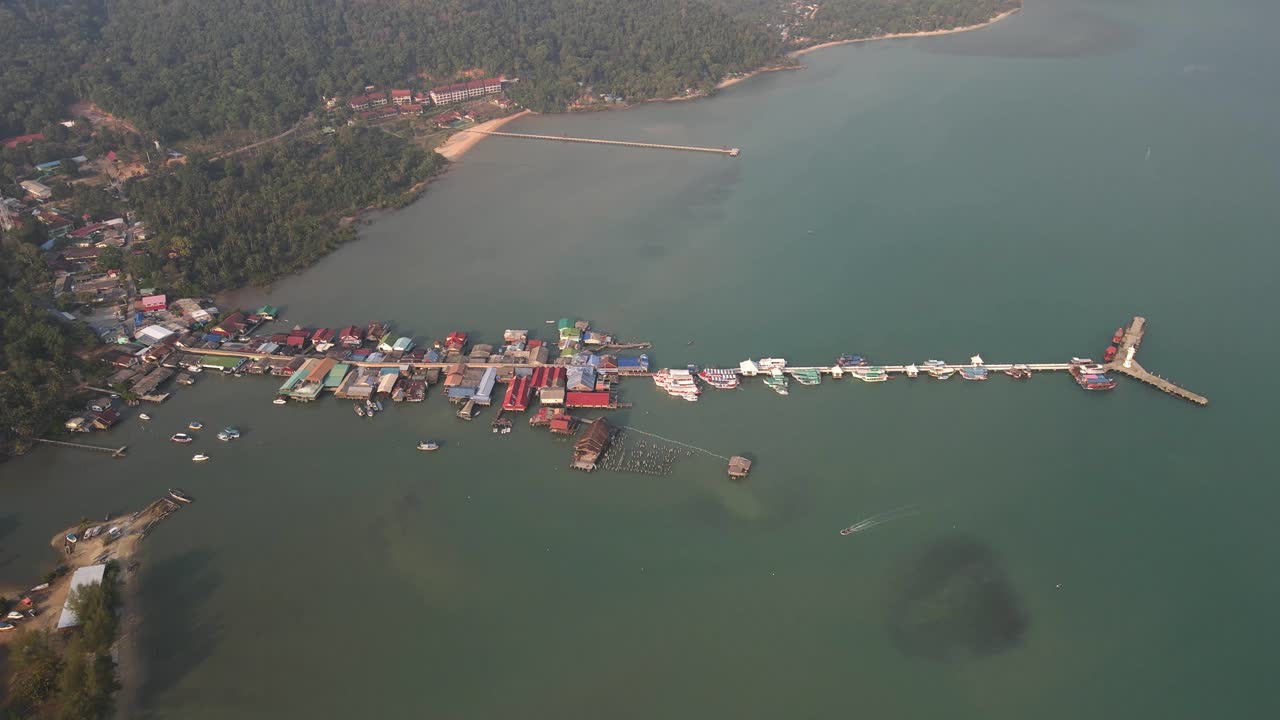 panorámica aérea lenta sobre el muelle de pesca bang bao y el pueblo a lo largo de la costa de la isla de la selva tropical koh chang, tailandia