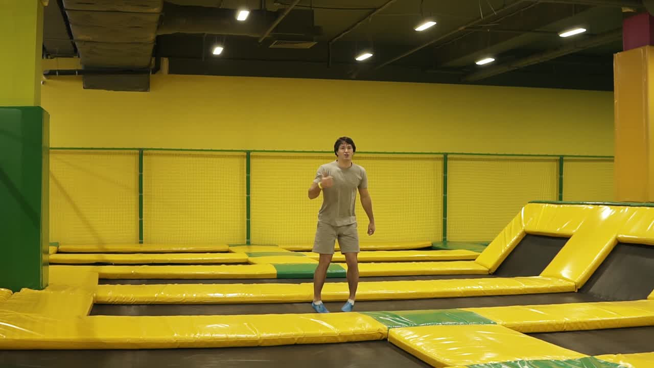 베이지색 티셔츠와 쇼트 입은 매력적인 젊은 소년이 뒤로 두 번의 돌풍을 일으킨다. 매우 운동적으로 남성으로 구성되었습니다.