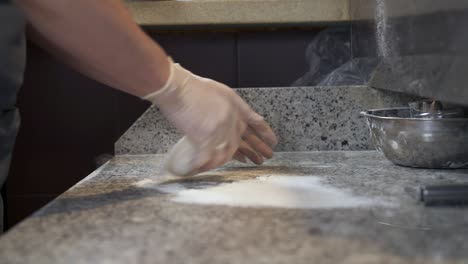 cocinar salpicando la harina sobre la masa y la superficie de la mesa de cocción para amasar