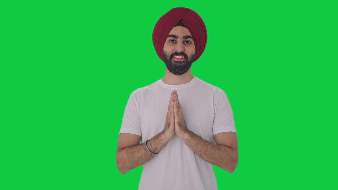Happy Sikh Indian man greeting and doing Namaste Green screen