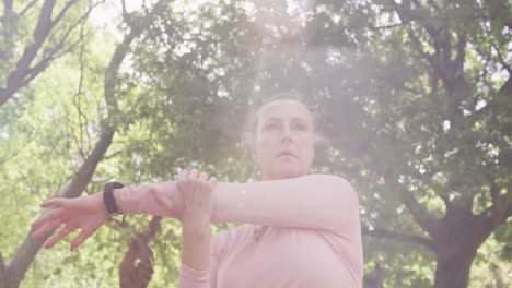 senior woman stretching her arms in the park