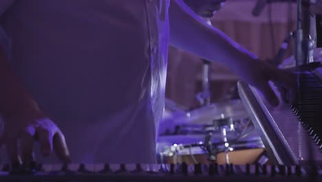 keyboardist plays on several musical instruments at a concert as part of a musical group