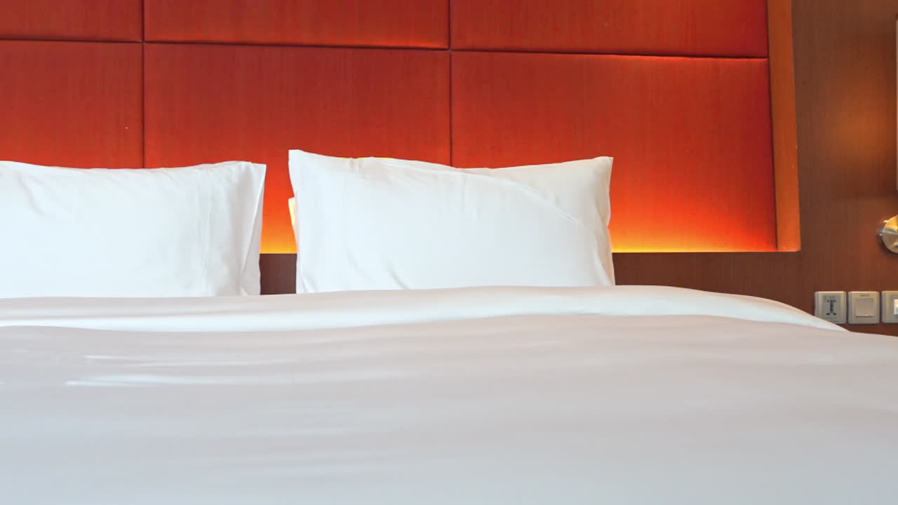 Tempat tidur kosong di kamar tidur resor hotel mewah, nyaman dan disiapkan untuk tamu, panoramis ke kiri