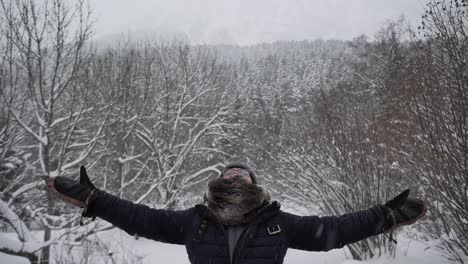 content woman in outerwear outstretching arms in winter forest