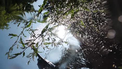 movimiento lento del agua que se vierte de la tina de riego con el destello del sol parpadeando