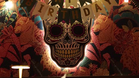 colorful birthday setup featuring skull artwork and balloons in a lively bangkok restaurant. warm lighting enhances the festive atmosphere