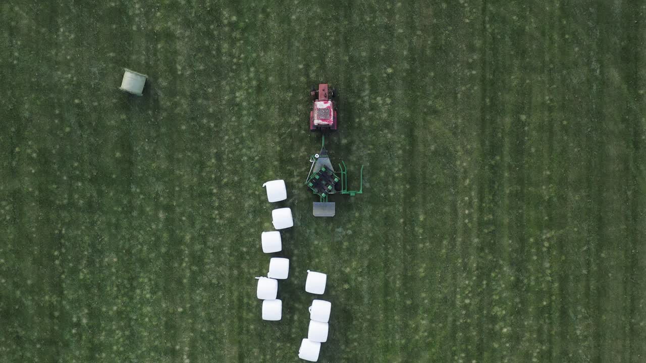 건조를 위해 건초 베일을 그린 필드에 떨어뜨리는 기계 포장 완료, 사료용 발효 공정