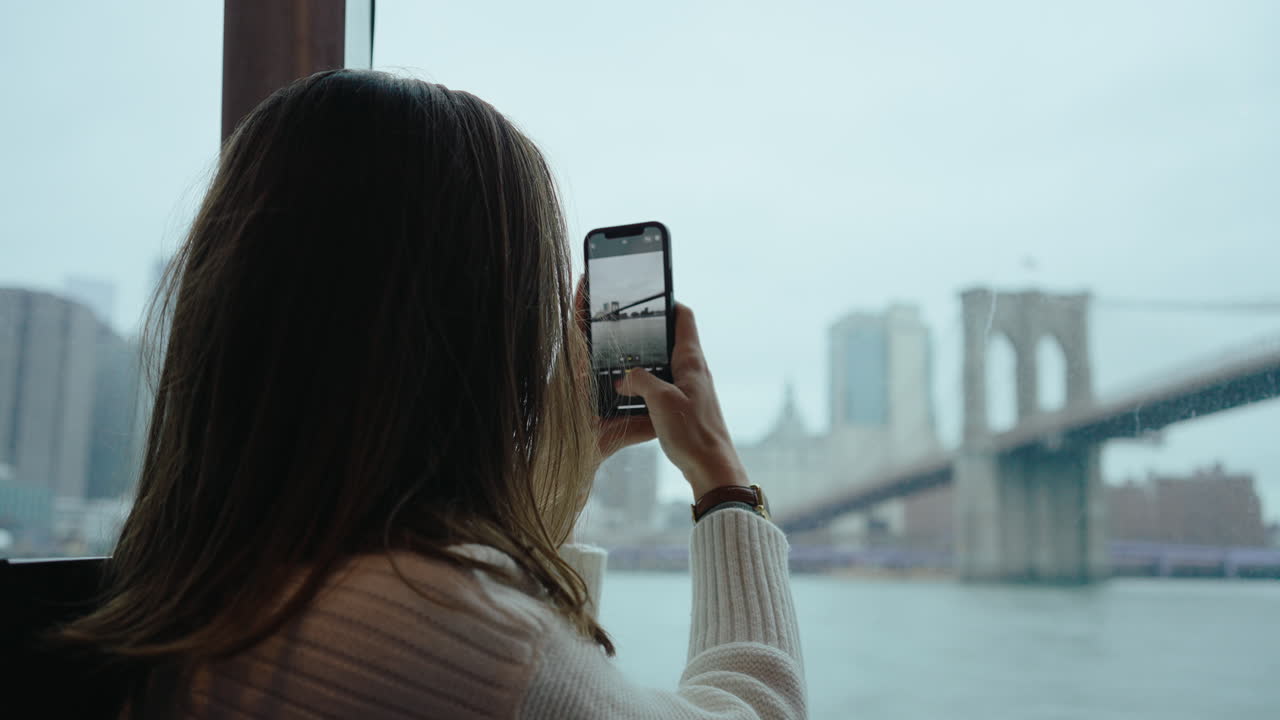 Woman Taking Picture of Brooklyn Bridge from Ferry