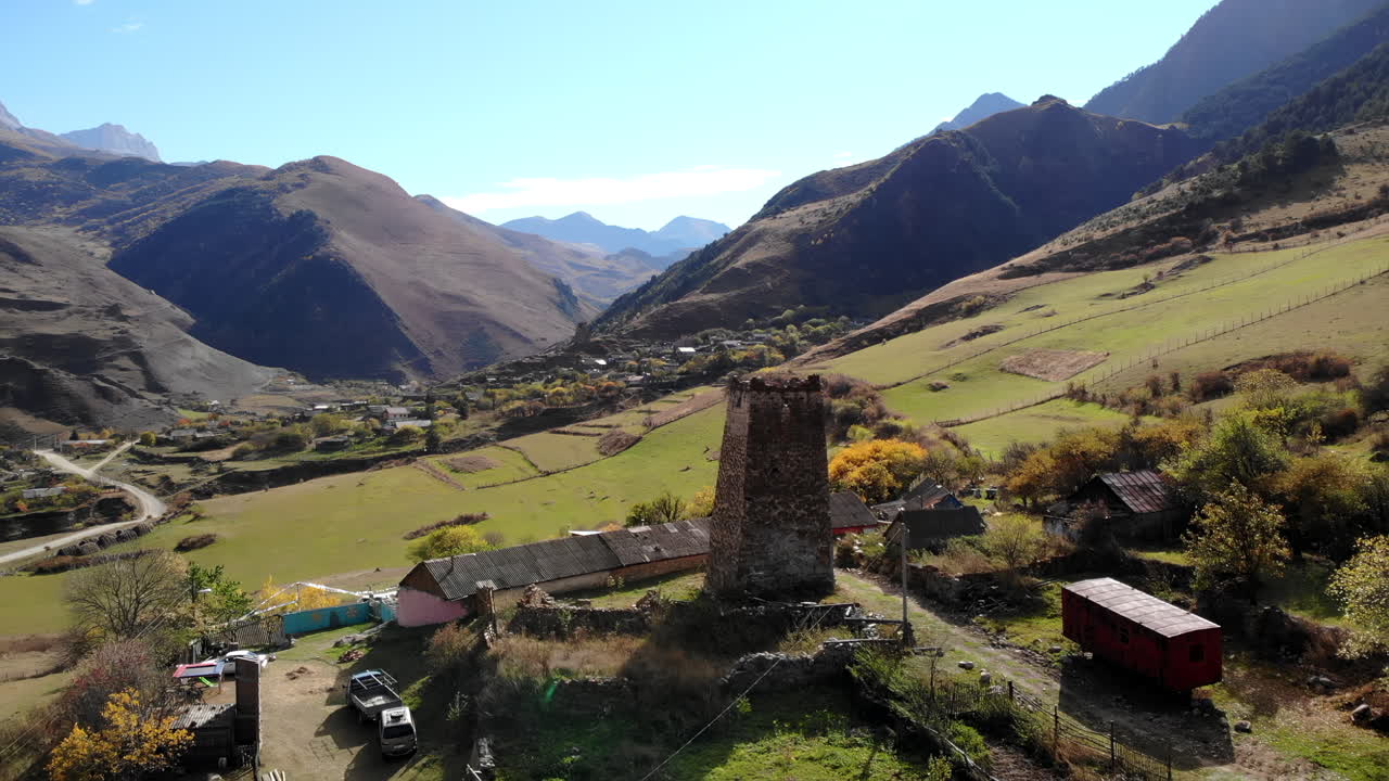 Vista aerea di un'antica torre di pietra in un villaggio di montagna.