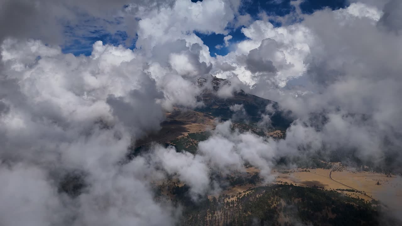 Panoramic shot of the Iztaccíhuatl volcano behind clouds and mist during a winter morning