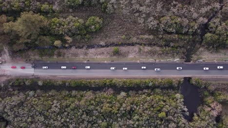 Imágenes-Aéreas-Dinámicas-De-Arriba-Hacia-Abajo-Del-Tráfico-Moderado-De-Vehículos-En-Una-Carretera-En-Uruguay,-Sudamérica