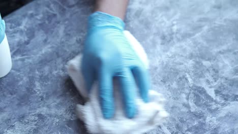 cleaning a gray countertop with gloves