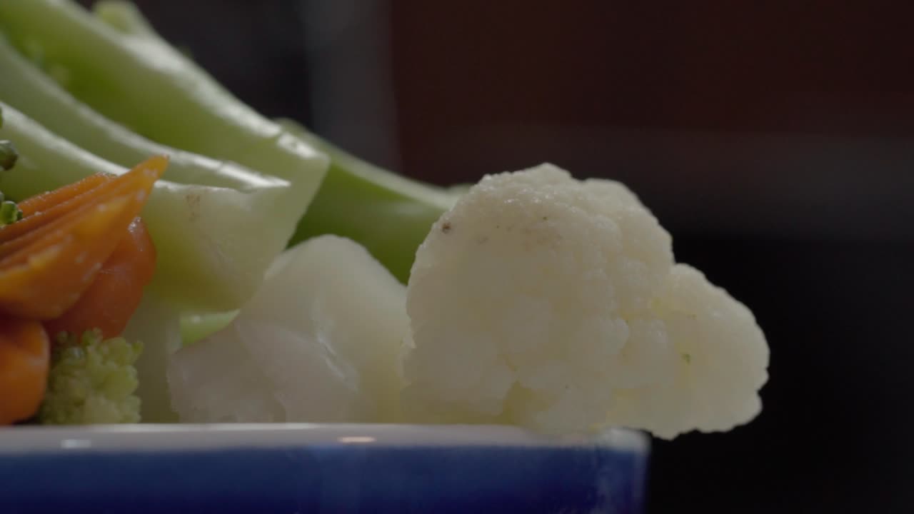 Close-up of a fresh, raw vegetable mix with carrot, celery, and cauliflower
