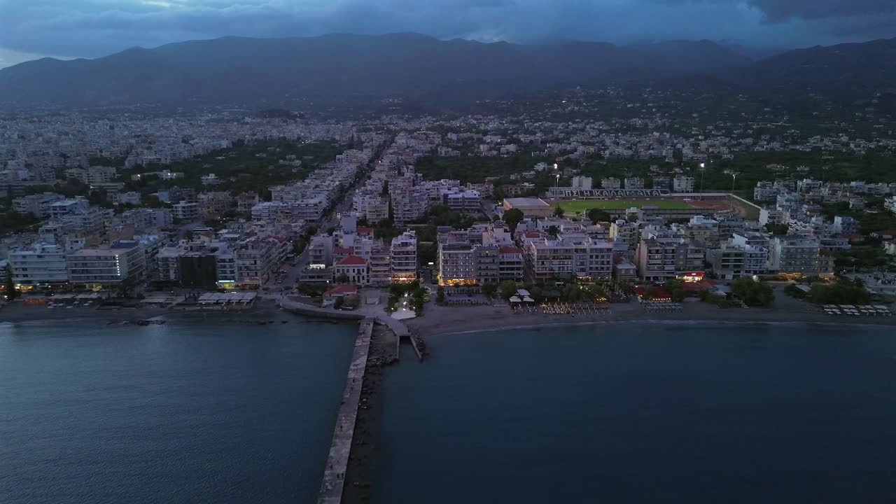 Imagens aéreas da paisagem urbana, aproximação de Kalamata pelo mar, movimento de drone de aproximação e descida em uma tarde nublada 4K