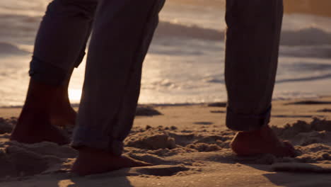 relajarse, la puesta de sol y la playa y los pies de la pareja caminando