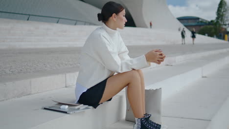 Girl-hipster-sitting-stairs-looking-city-street.-Woman-relaxing-on-staircase.