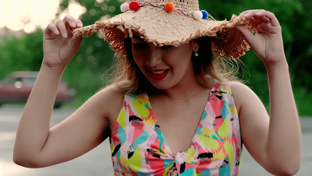 una chica embarazada camina con un hermoso vestido y sombrero