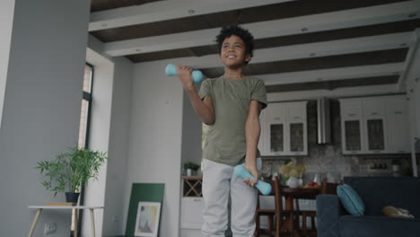 young boy exercising with dumbbells at home