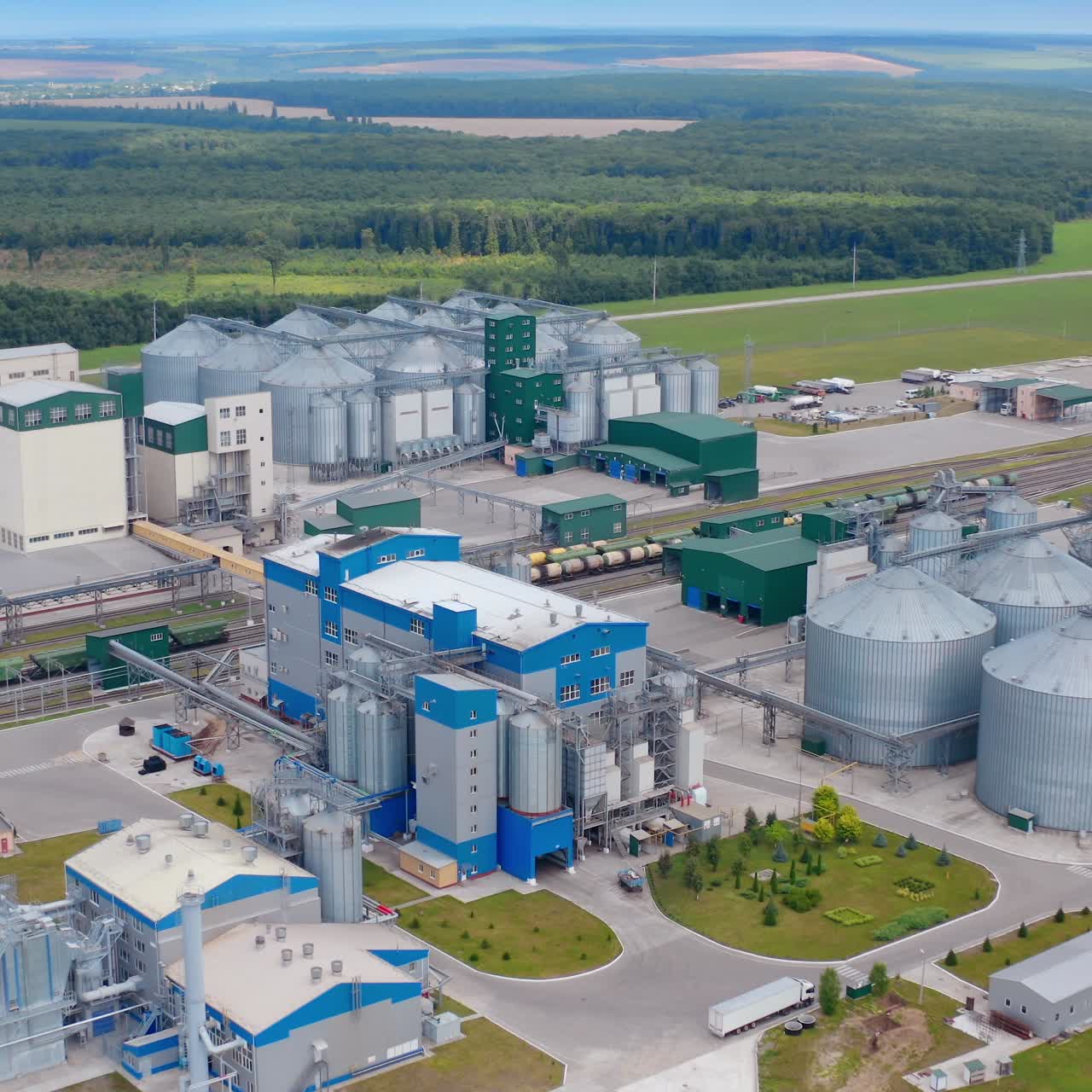 Exterior of a modern plant on a field. Large grain elevators for seed processing. New industrial area in the countryside. Aerial view