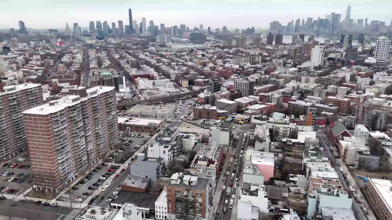 Horizontal drone arc shot over 11th Avenue in New York, capturing the city's vibrant streets, towering skyscrapers, and dynamic urban skyline with a smooth sweeping motion.