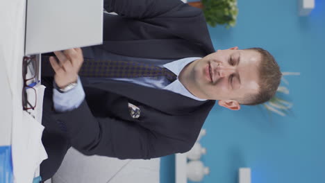 vertical video of home office worker man rejoices at what he sees on the laptop.