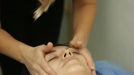 woman getting spa treatment. young pretty woman enjoying face massage procedure